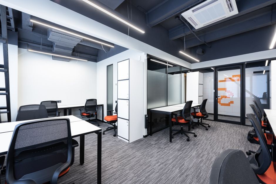 White tables with armchairs in modern spacious workspace with white cupboards and glass door in office of contemporary business center