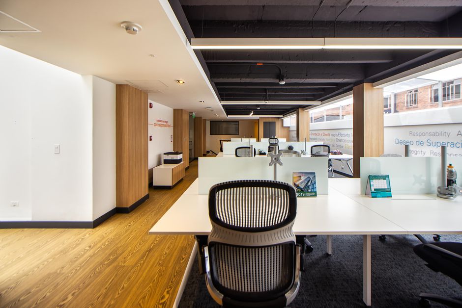 Spacious and well-lit modern open plan office with minimalist design and sleek furniture.